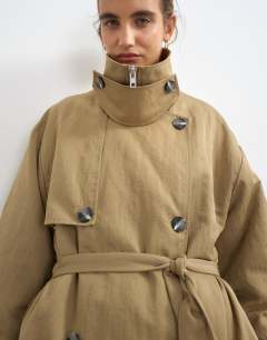 Model wearing Funnel neck trench in camel