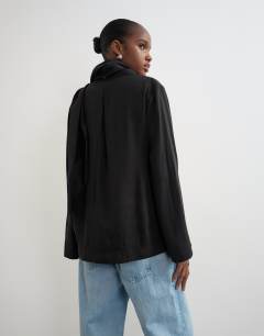 Model wearing Funnel neck zip top with fringe scarf detail in black