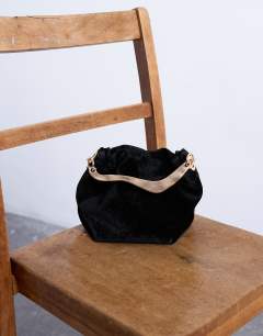 Model wearing Gabriette small velvet metal trim handle grab bag in black