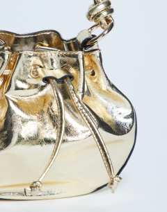 Model wearing Gabs ruched drawstring bell bag in gold
