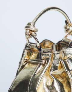 Model wearing Gabs ruched drawstring bell bag in gold