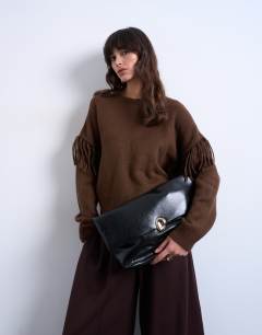Model wearing Gaia folded clutch bag with hardware in black