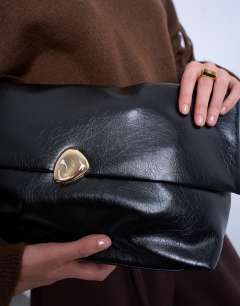Model wearing Gaia folded clutch bag with hardware in black