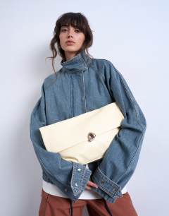 Model wearing Gaia folded clutch with hardware in off white
