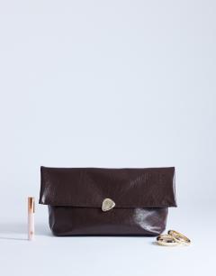 Model wearing Gaia large clutch bag with gold hardware in chocolate