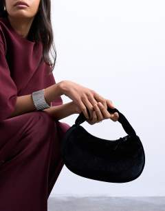 Model wearing Gail twist handle velvet grab bag in black