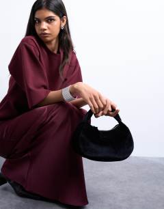 Model wearing Gail twist handle velvet grab bag in black