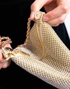 Model wearing Galaxy diamante grab bag in gold