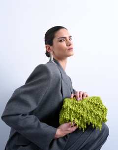 Model wearing Garison bead and embellished clutch in green