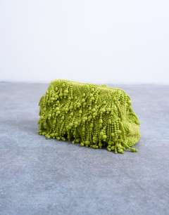 Model wearing Garison bead and embellished clutch in green