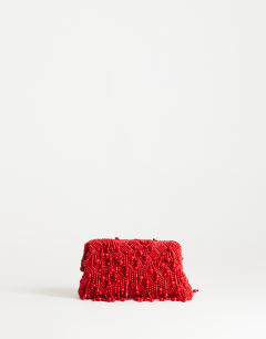 Model wearing Garison bead and embellished clutch in red