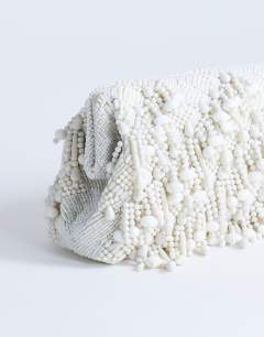 Model wearing Garison small bead and embellished clutch in white