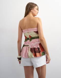 Model wearing Gathered bust bandeau with peplum hem in abstract print