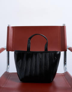 Model wearing Gemma medium stripe faux leather grab bag in black