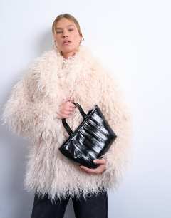 Model wearing Gemma medium stripe faux leather grab bag in black