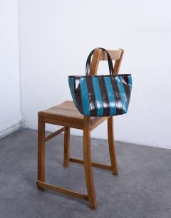 Model wearing Gemma stripe faux leather grab bag in blue and brown
