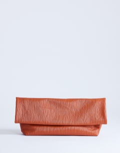 Model wearing George clutch bag in rust