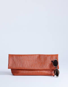 Model wearing George clutch bag in rust