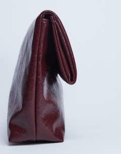 Model wearing Georgia folded clutch grab bag in burgundy