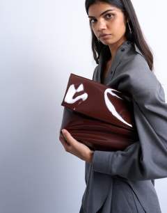 Model wearing Georgia folded clutch grab bag in chocolate patent