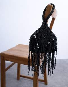 Model wearing Giana sequin tassel grab bag in black