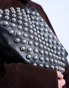 Model wearing Gideon studded clutch bag in black