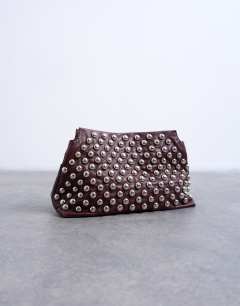Model wearing Gideon studded clutch bag in burgundy