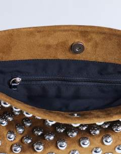 Model wearing Gideon studded clutch bag in tan