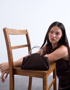 Model wearing Ginny metal handle grab bag in chocolate