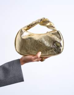 Model wearing Gladys grab bag in gold