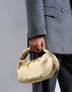 Model wearing Gladys grab bag in gold