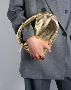 Model wearing Gladys grab bag in gold