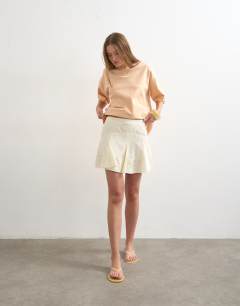 Model wearing Godet hem mini skirt in cream