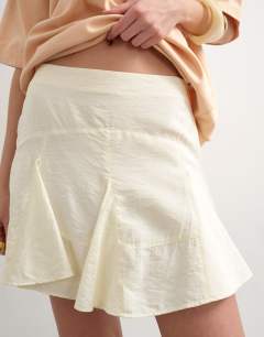 Model wearing Godet hem mini skirt in cream