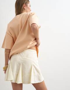 Model wearing Godet hem mini skirt in cream