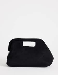 Model wearing Gordan medium suedette clutch with handle in black
