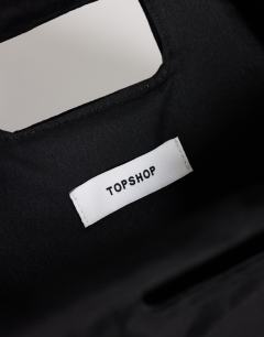 Model wearing Gordan medium suedette clutch with handle in black
