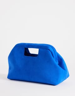 Model wearing Gordan medium suedette clutch with handle in cobalt