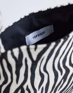 Model wearing Gracie small hair on leather grab bag in zebra