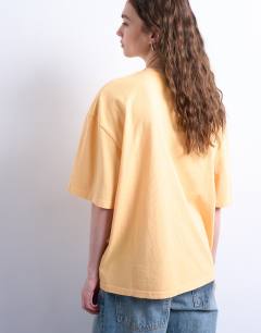 Model wearing Graphic flower print oversized tee in orange