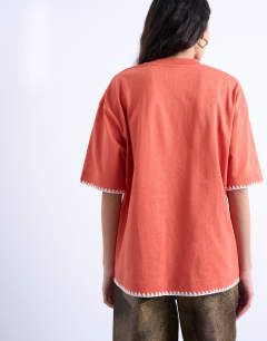 Model wearing Graphic Havana oversized whip stitch tee in orange