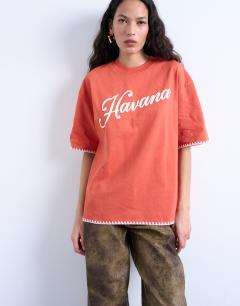 Model wearing Graphic Havana oversized whip stitch tee in orange