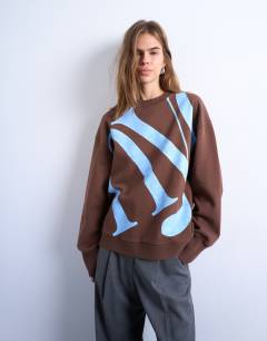 Model wearing Graphic NYC oversized sweatshirt in chocolate brown