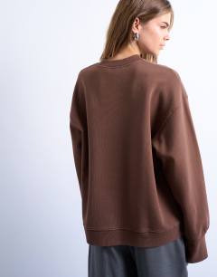 Model wearing Graphic NYC oversized sweatshirt in chocolate brown