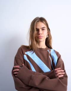 Model wearing Graphic NYC oversized sweatshirt in chocolate brown
