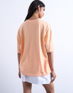 Model wearing Graphic Tulum oversized tee in orange