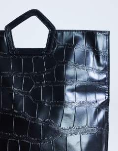 Model wearing Gregry folded clutch bag in black croc