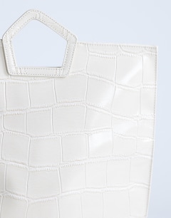 Model wearing Gregry folded clutch bag in off white croc