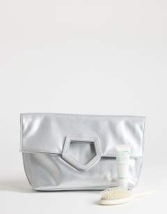 Model wearing Gregry oversized folded clutch bag in silver