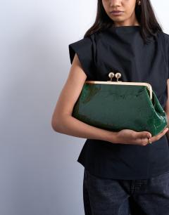 Model wearing Gretchen clutch grab back in green